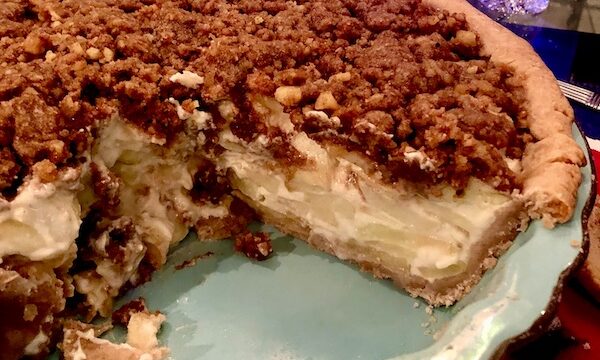 Aqua pie pan with Candied Apple Walnut Pie that's got a large wedge cut from it.