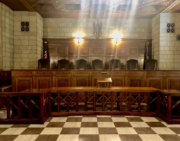 Large room with black and white checkered floor and wood dais with black chairs is the Supreme Court in the Nebraska State Capitol in Lincoln