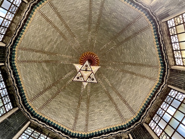 White glass star shaped light hangs from domed ceiling in the Nebraska State Capitol in Lincoln