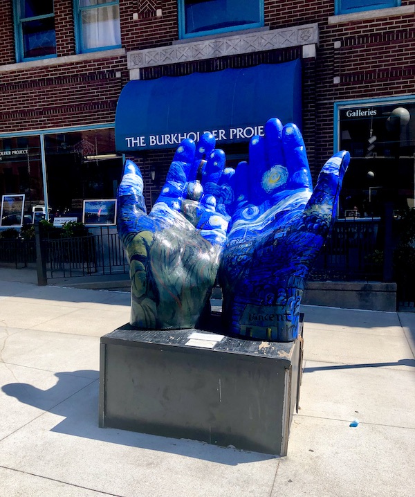 Sculpture of a pair of hands painted blue with artwork was just Some Highlights of Lincoln NE