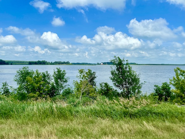 Large lake surrounded by grass and bushes en route to Trinity Heights Sioux City IA