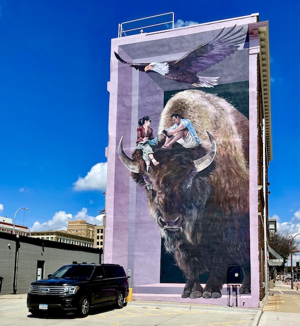Mural of a bison with a man and woman sitting on its head in Sioux City IA