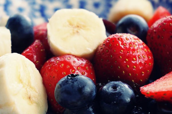 Fresh sliced bananas, whole strawberries and blueberries at peak season one of 4 Factors to Consider When Planning Fruit Desserts