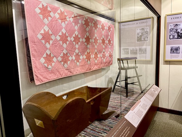 Red and white quilt, wood crib and high chair on display at Herbert Hoover National Historic Site Iowa