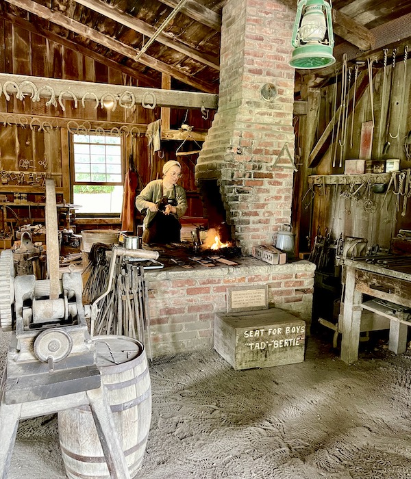A female blacksmith heating iron on the fire at the Herbert Hoover National Historic Site Iowa