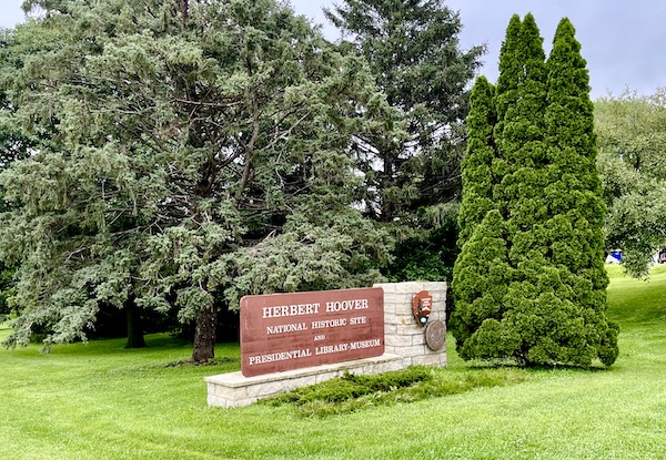 Lawn, evergreen trees and a wall welcoming you to Herbert Hoover National Historic Site Iowa