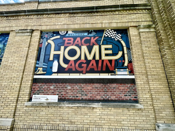 Colorful mural with wording Welcome Back Home Again and bottle of milk at the Indianapolis Speedway Indiana