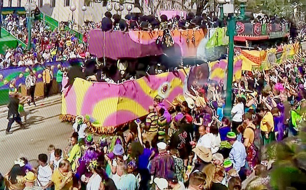 Pink and yellow two tiered float on parade route for Mardi Gras 2023 New Orleans