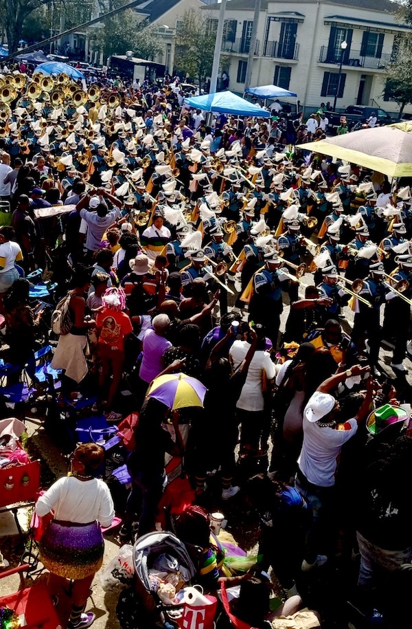 Marching band parades through a crowd during Mardi Gras 2023 New Orleans