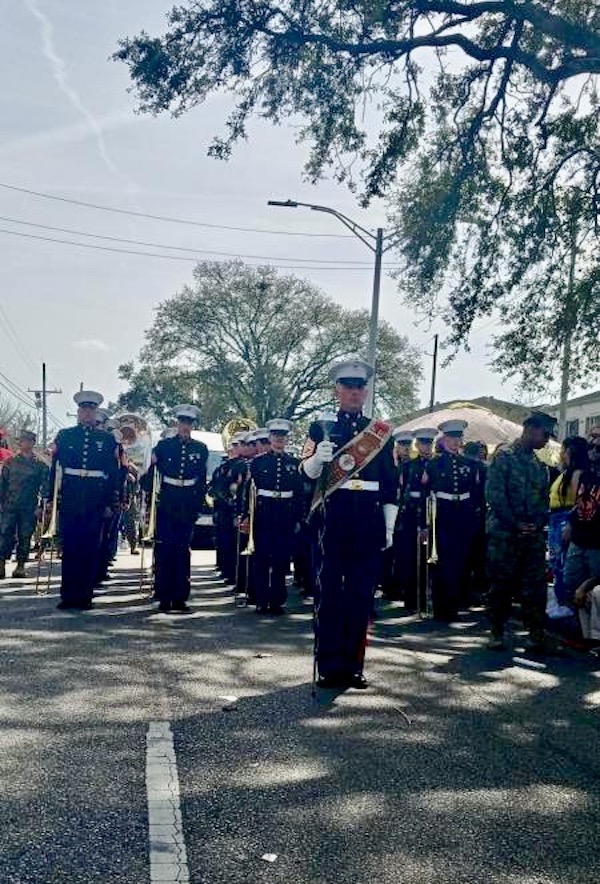 A military band marches through the crowd during Mardi Gras 2023 New Orleans