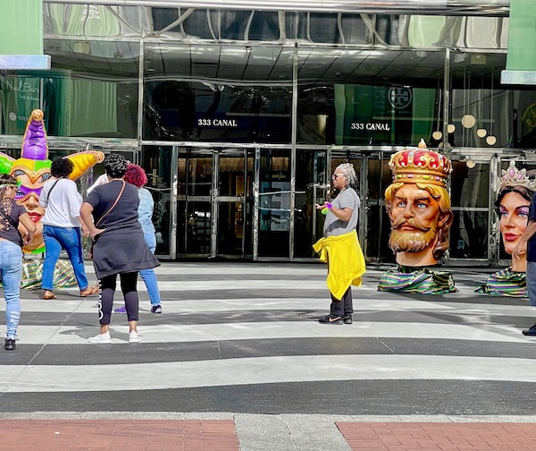 Mardi Gras figures in front of a shopping mall entrance.