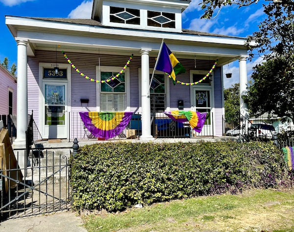 House with white pillars and Mardi Gras decorations.