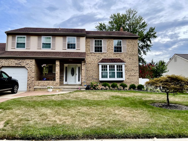 Brown brick single house with bay window in NJ.