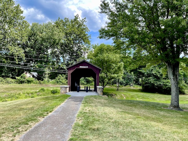 An old wooden covered bridge at a park is one of the Covered Bridges of Pennsylvania