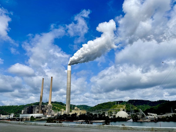 Tall white smoke stacks at a factory on the river in West Virginia