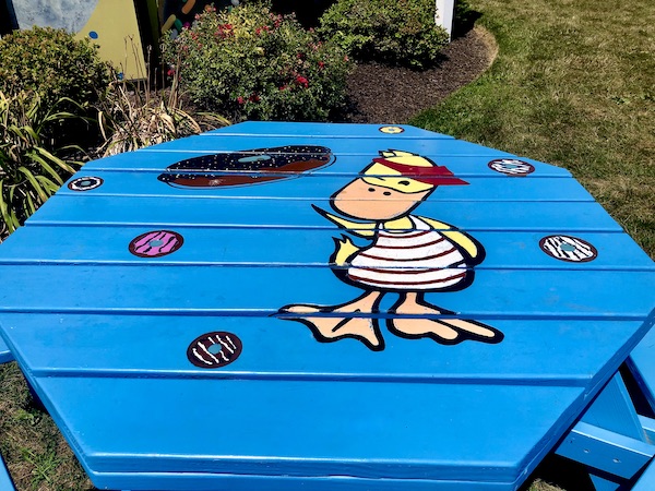Bright blue outdoor table with a duck painted on it at Duck Donuts Mechanicsburg PA