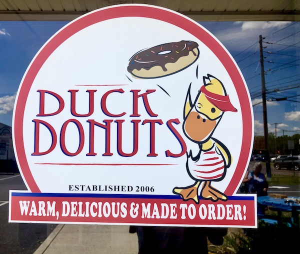 Front window of Duck Donuts Mechanicsburg PA, red and white logo with ducky and donut