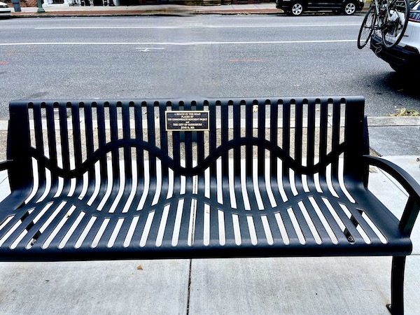 Black wrought iron bench at the curb of a street is near the Pennsylvania State Capitol Harrisburg