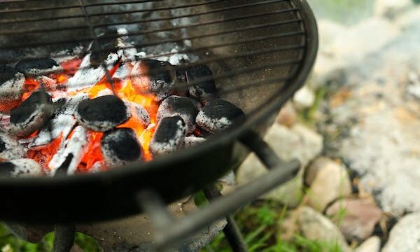 A black round grill with burning charcoal is one suggestion for The Perfect Backyard BBQ