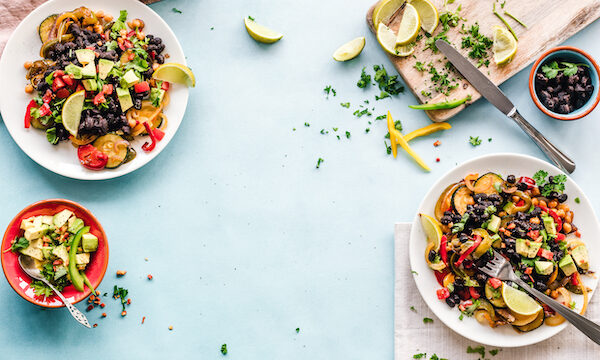 White plates topped with fruit salad on an aqua surface for Ways to Eat Healthfully When Busy