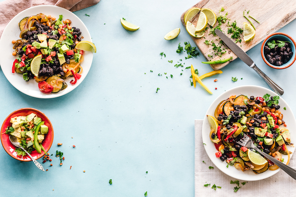White plates topped with fruit salad on an aqua surface for Ways to Eat Healthfully When Busy