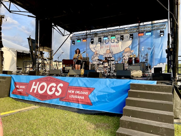 A female singer and guitar player performing on stage at Hogs For The Cause NOLA