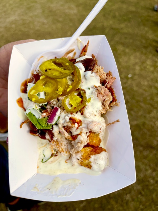 White paper platter holding pulled pork, tots, sauce and jalapeños at Hogs For The Cause NOLA
