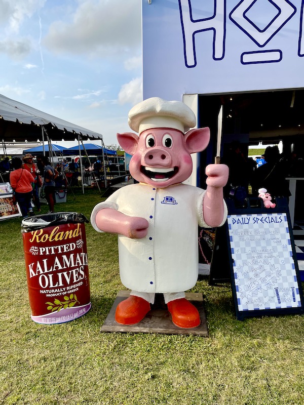 A cute pig statue with a can of Kalamata olives at Hogs For The Cause NOLA