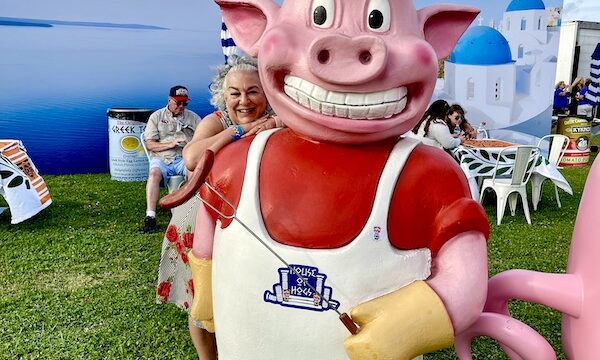 A pig statue with cap, apron and long fork with sausage at Hogs For The Cause NOLA