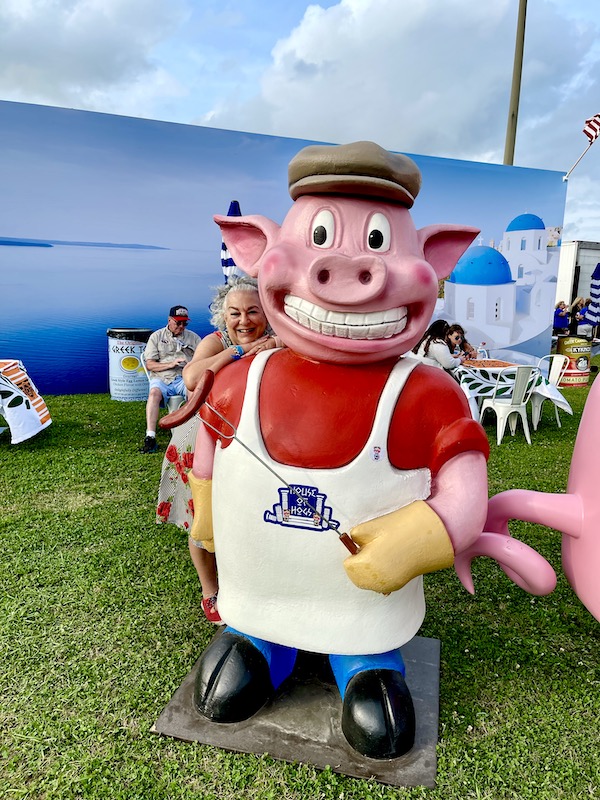 A pig statue with cap, apron and long fork with sausage at Hogs For The Cause NOLA