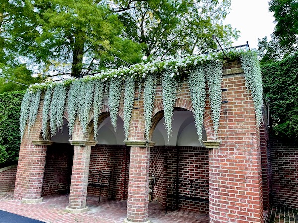 Sage green plants hang down over the brick arches at Longwood Gardens Kennett Square PA