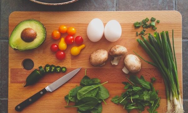 Cutting board topped with knife, eggs, and produce to help Reigniting Your Passion for Home Cooking