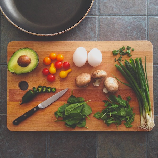 Cutting board topped with knife, eggs, and produce to help Reigniting Your Passion for Home Cooking