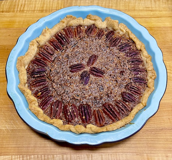 Blue pie plate holding a pecan pie from new book Available Now Tasting Alabama