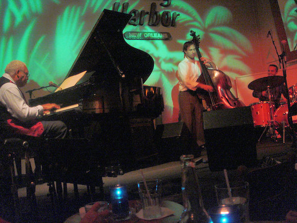 Colorfully lit stage of a Jazz club with a trio of musicians performing, Celebrating 3 Years as Full Time RVers!