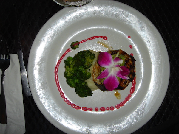 Pearly white plate artistically topped with broccoli and other food and an orchid Celebrating 3 Years as Full Time RVers!