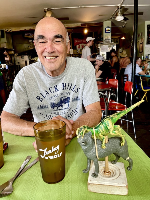 Man in gray T-shirt sitting a a table waiting for lunch to be served in the big easy.