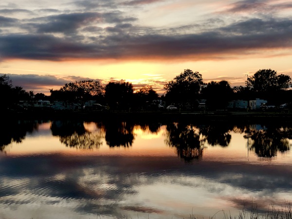 Trees and sunset reflecting in the lake at our RV park by Lake Okeechobee Florida