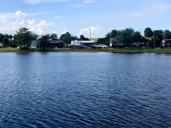 An RV with awning out and water in front near Lake Okeechobee Florida