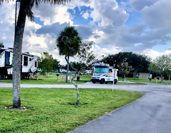 An RV park with our Class A RV and Jeep parked by Lake Okeechobee Florida