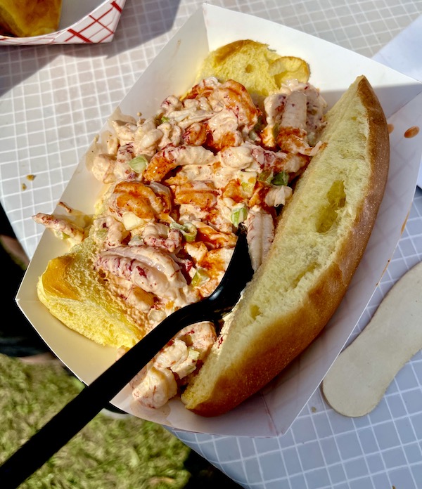 A long soft roll fill with crawfish salad and topped with a drizzle of hot sauce at New Orleans Jazz and Heritage Festival