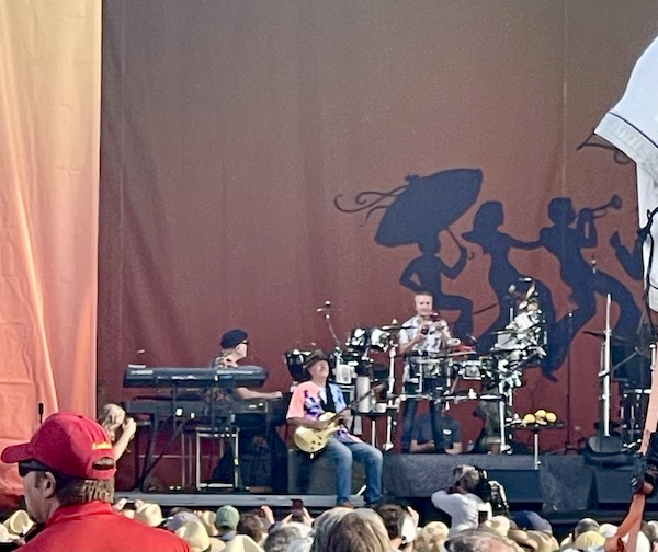 Band with guitarist seated on stage at New Orleans Jazz and Heritage Festival