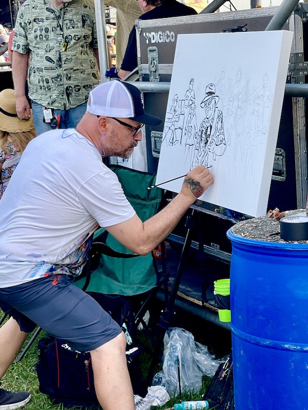 Artist beginning a new painting at New Orleans Jazz and Heritage Festival