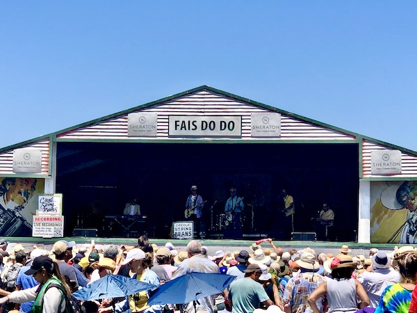 Another stage at New Orleans Jazz and Heritage Festival with musicians performing and lots of people listening