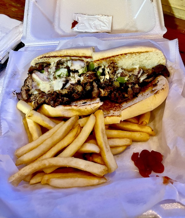 Styro clamshell holding a cheese steak and fries at our second stop from NOLA to Lake Worth Florida