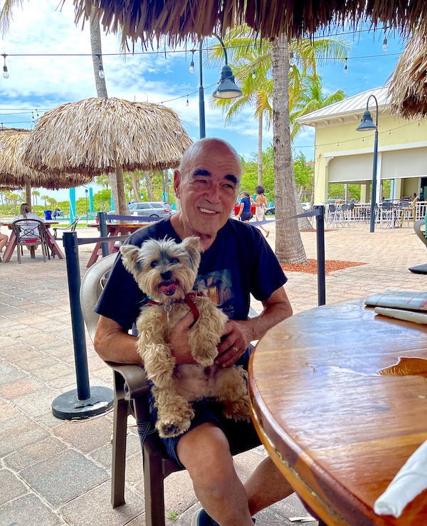 Steve and our Yorkie at restaurant by the beach.