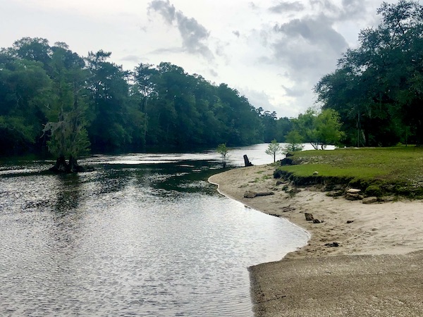 The Yellow River with sandy bank and lots of trees at first stop from NOLA to Lake Worth Florida