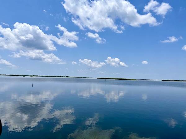 Calm water with puffy cloud reflected in it seen on our Sunday Drive to Louisiana Southernmost Point
