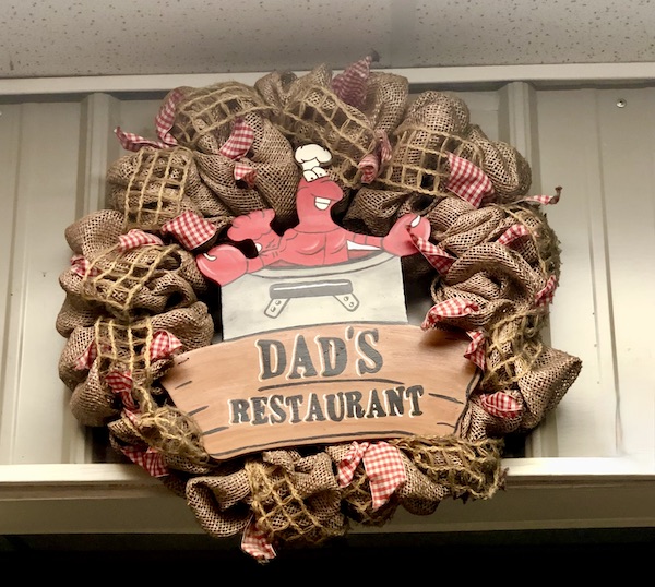 Burlap and red and white checked fabric create a wreath with lobster and sign for Dad's Restaurant