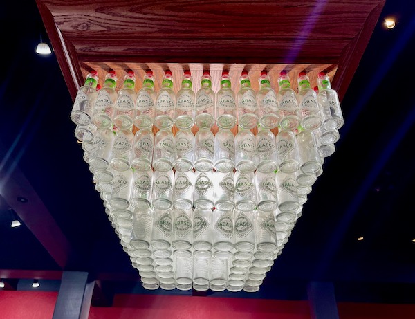 Light fixture made of lots of empty iconic Tabasco bottles.